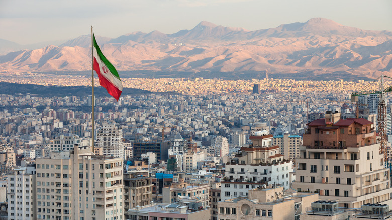The city of Tehran with the waving Iranian flag in the foreground.