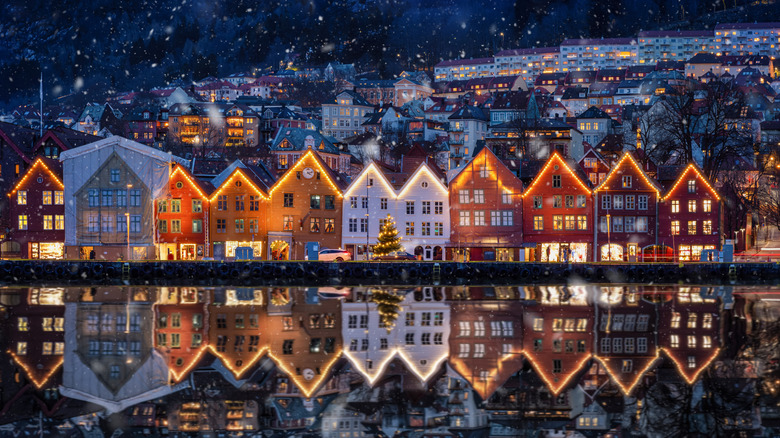 Winter dusk view of the famous Bryggen district at Bergen, Norway, decorated for Christmas with snow.