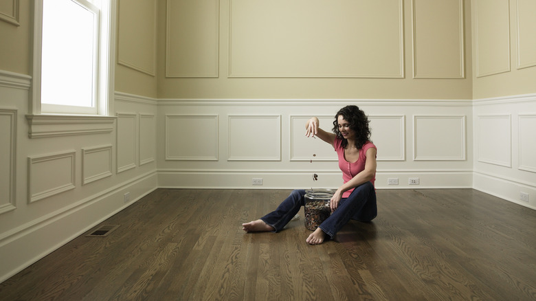 Woman saving money in empty house