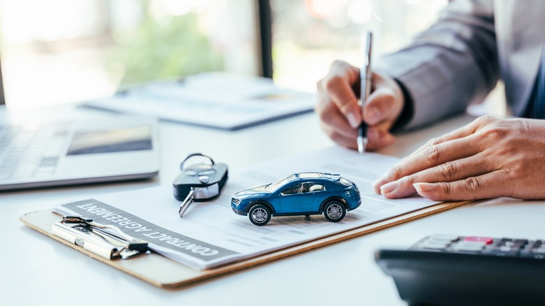 signing papers at dealership
