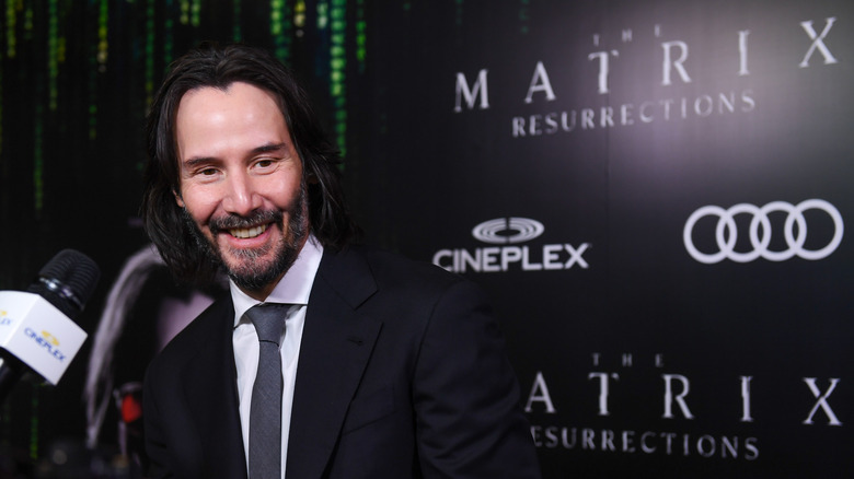 Keanu Reeves smiling for photographers