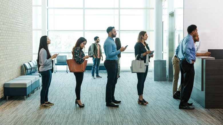 A line of customers at business desk
