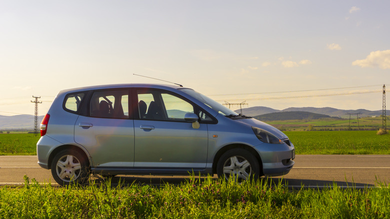 Blue car Honda Jazz parked on the road