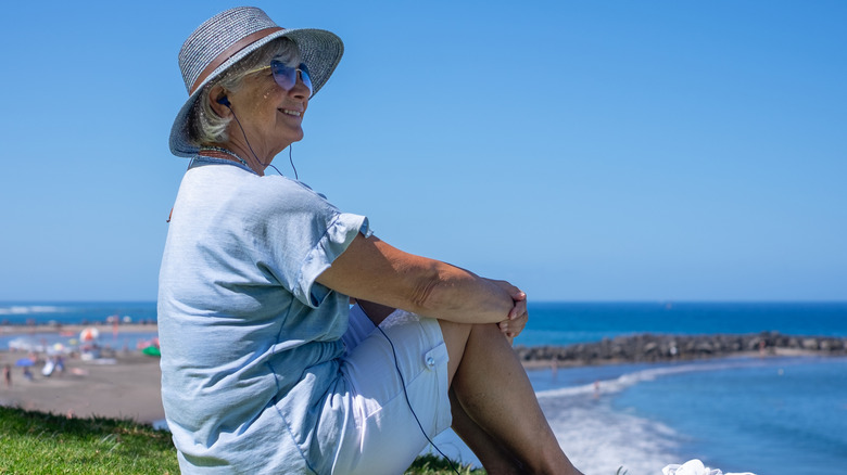 Photo of a senior woman sitting and enjoying a peaceful coastline