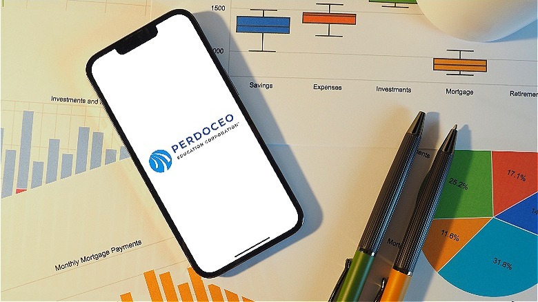 Perdoceo on phone on desk
