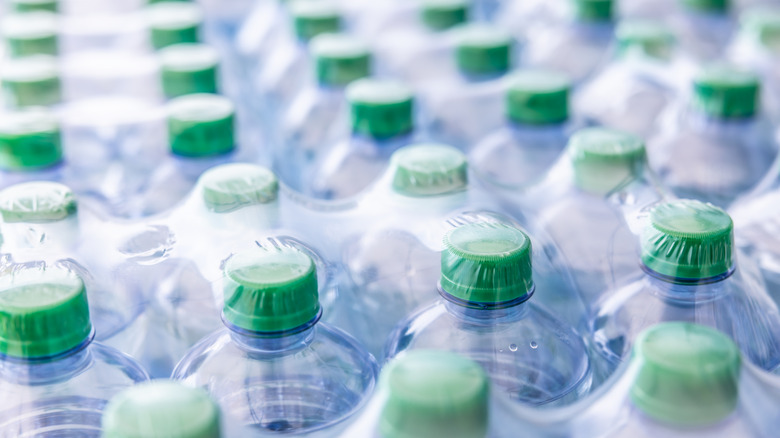 Bottles of water lined up in plastic packaging