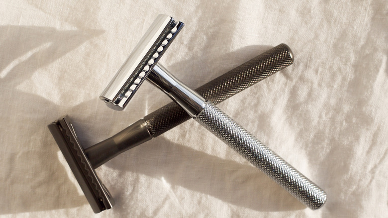 Two metal handle razors on a towel