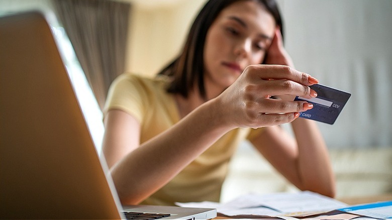 Person upset, holding credit card
