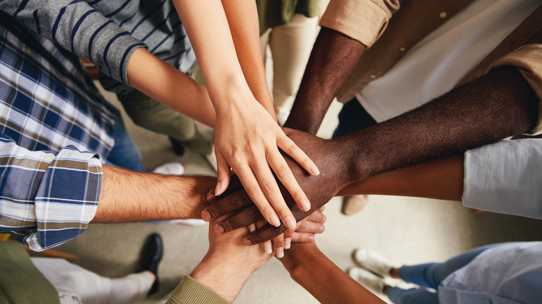 group putting their hands into center