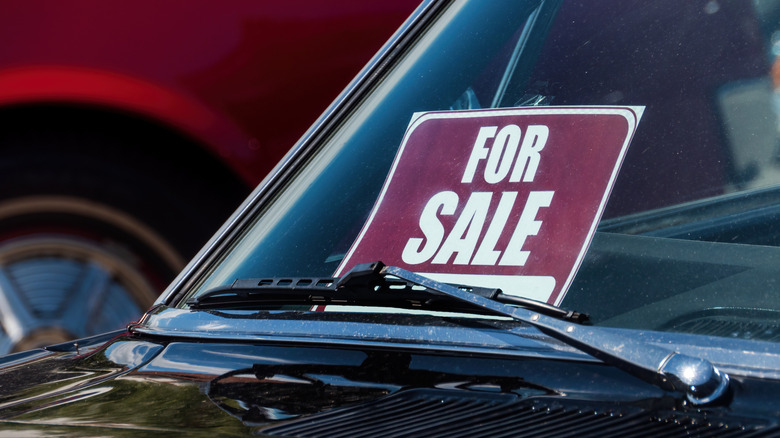 A car with For Sale sign on the windshield