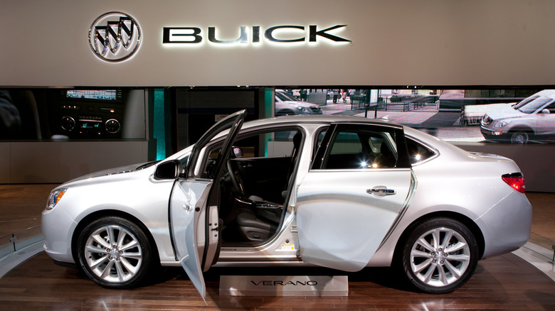 Side view of a 2013 Buick Verano in a Buick dealership with two doors open