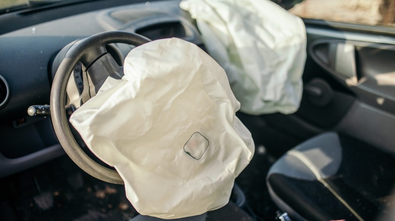Deployed driver and passenger airbags inside a car after a collision