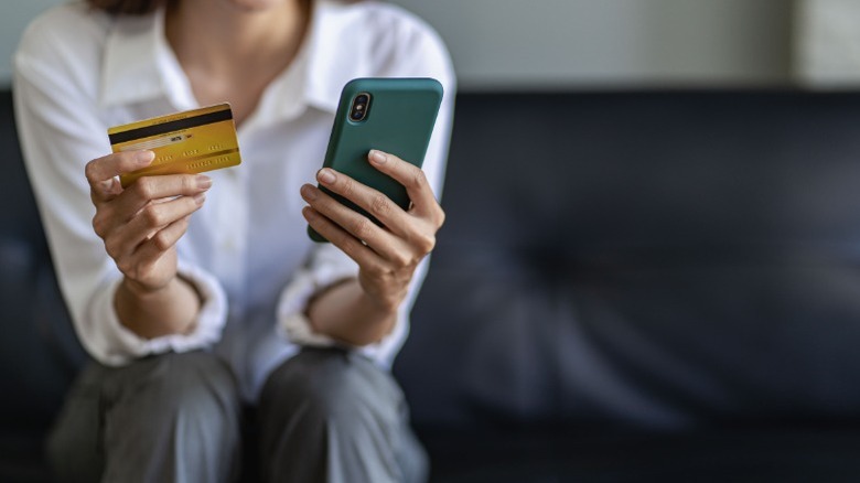 A person using their phone to make a credit card payment