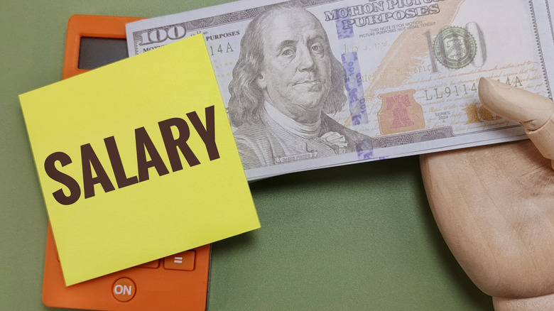 note reading salary and $100 bills