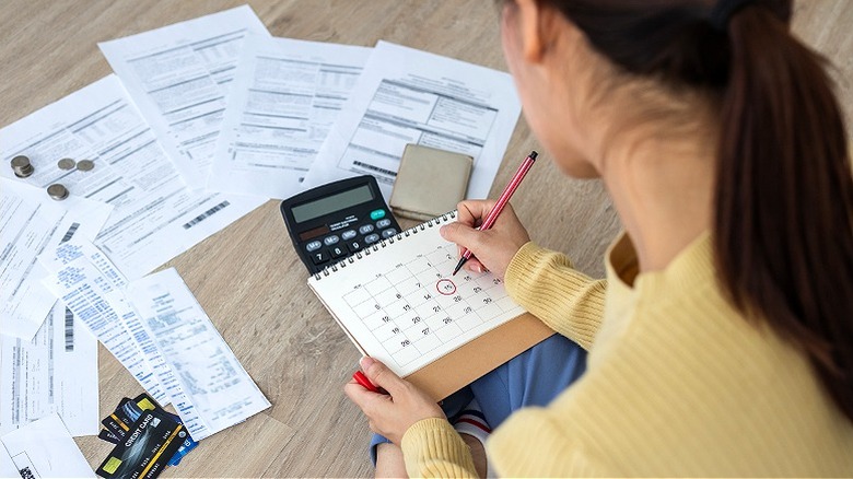 Person with paperwork, marking calendar