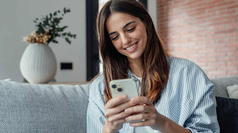 Smiling woman looking at smartphone screen
