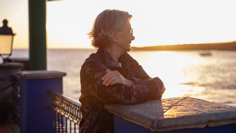 Senior woman on a deck admiring the view of the water
