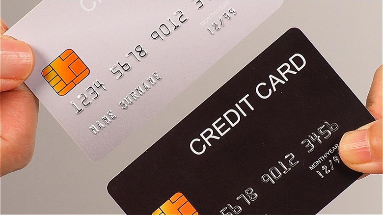 Two hands holding credit cards