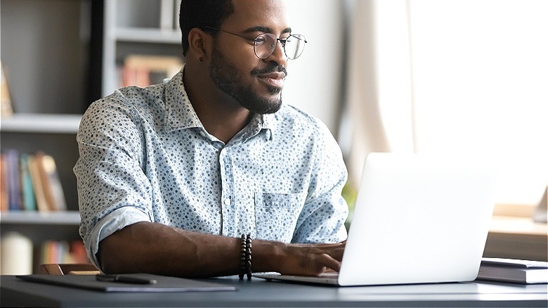 Person writing on a laptop