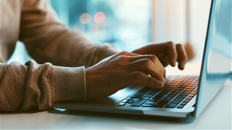 blogger typing on laptop
