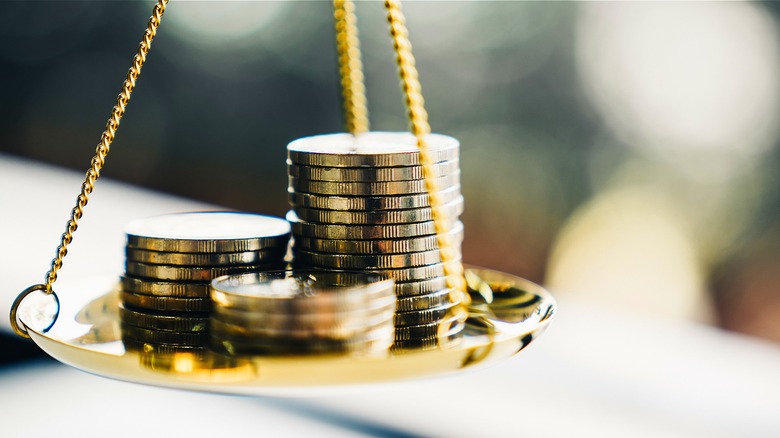 Golden coins weighing down scale