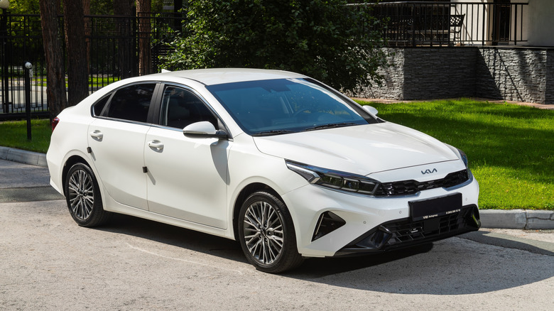 A white Kia Forte parked on a driveway.