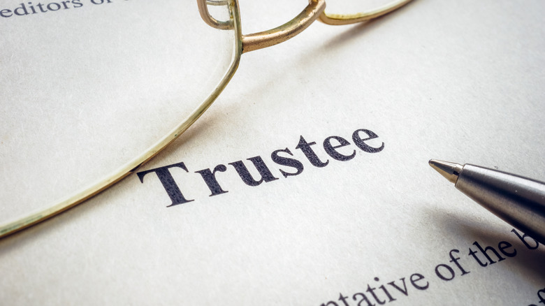 The word trustee near glasses and the pen.