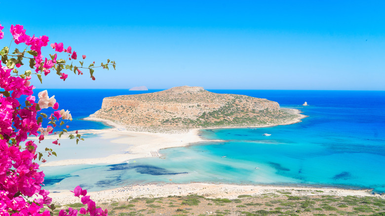 Waters off the island of Crete and bougainvillea flowers in the foreground