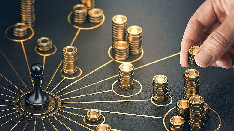 Hand stacks gold coins