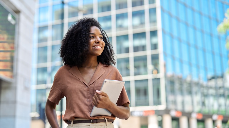 Professional man standing at office window looking at city view