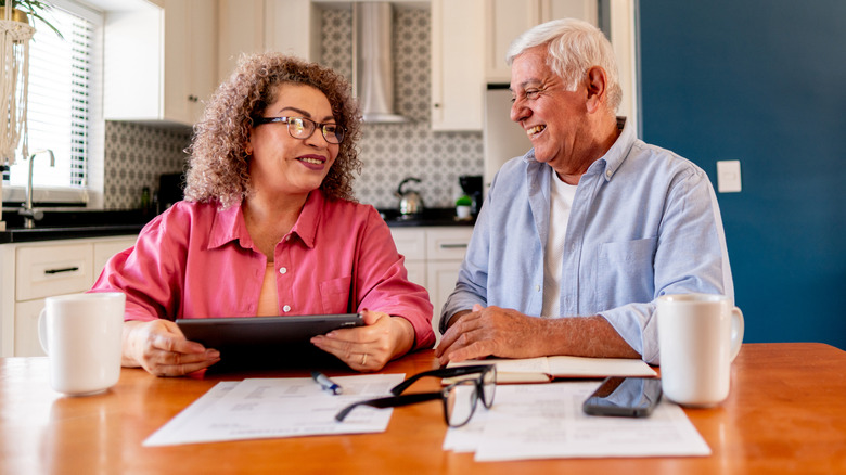 Senior coupe at dinning room table with documents in front of them
