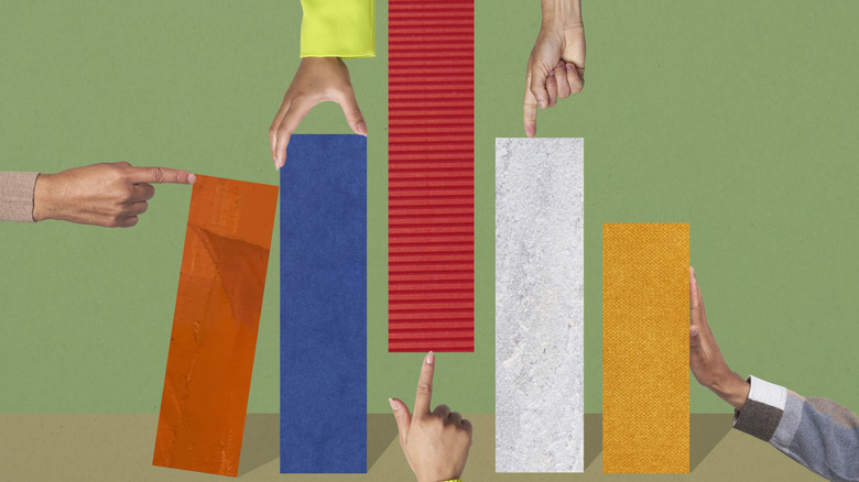 A multitude of hands push and pull elements of a colorful bar graph, against a green background.