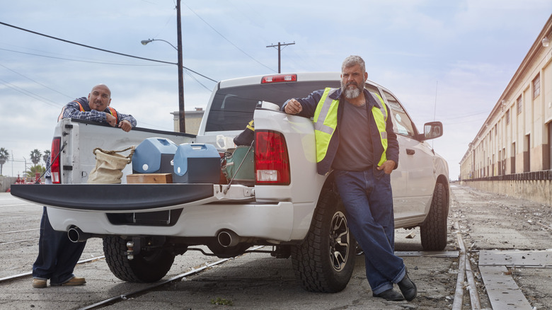 Construction workers eating lunch out of the back of a pick up truck