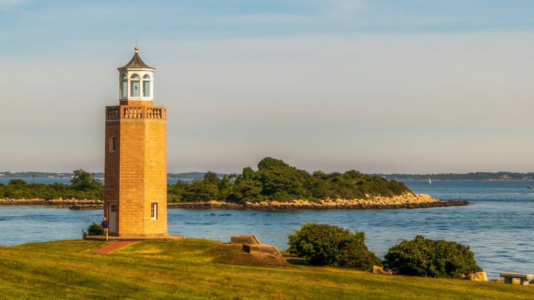A picture-postcard view of Groton, CT's Avery Point lighthouse, overlooking the Thames river shoreline.