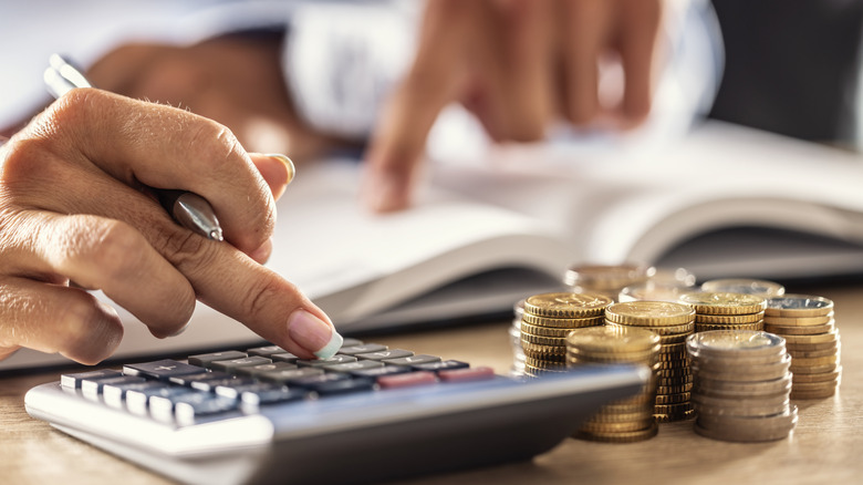 Hands using calculator to plan housing finances