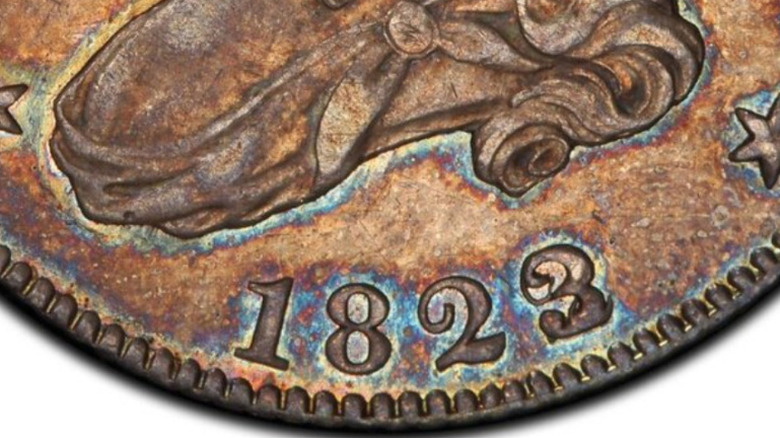 An extreme close-up of an 1823/2 overdated capped bust quarter.