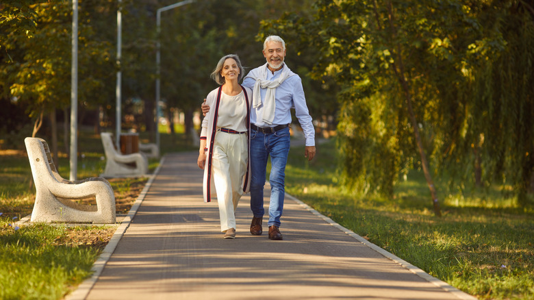 a retired couple walking in a park