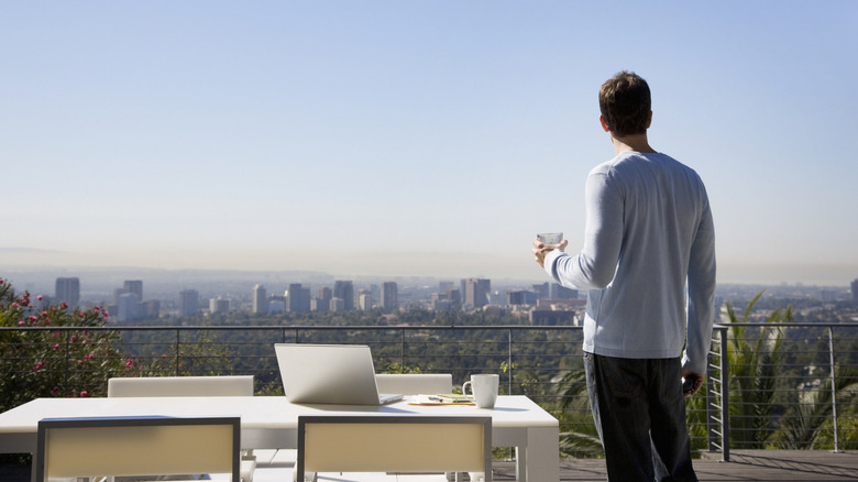 man looking at city from back patio
