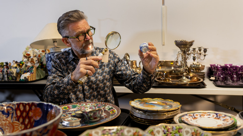 Man inspecting various vintage collectibles