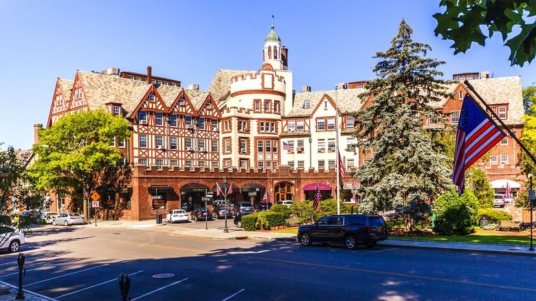 A mixed-use brick building with a parking lot filled with cars