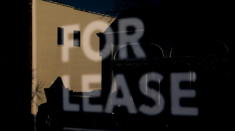 For Lease sign in window with reflection of building