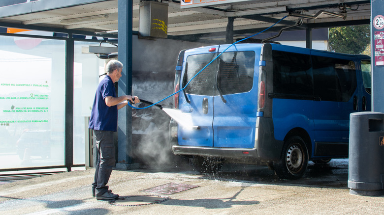 a person hosing down a van
