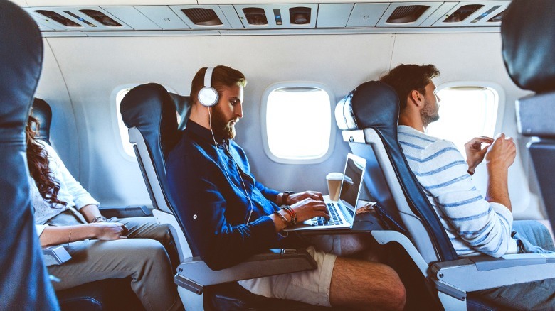 Person on laptop in airplane