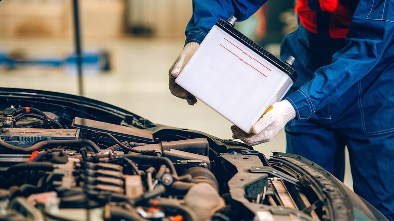 Person replacing battery in car