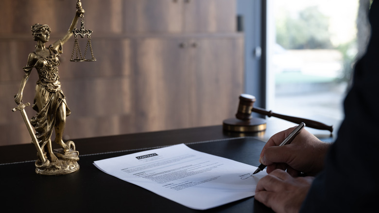 A judge or legal advisor fills out paperwork.