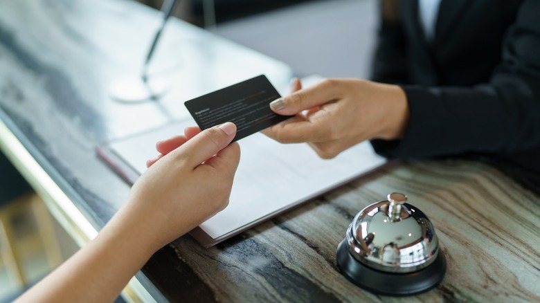 Customer handing credit card to hotel check-in staff