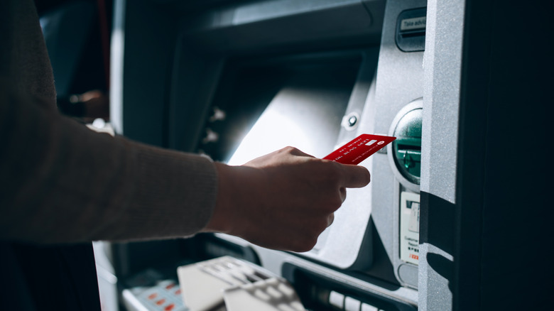 closeup of person using ATM