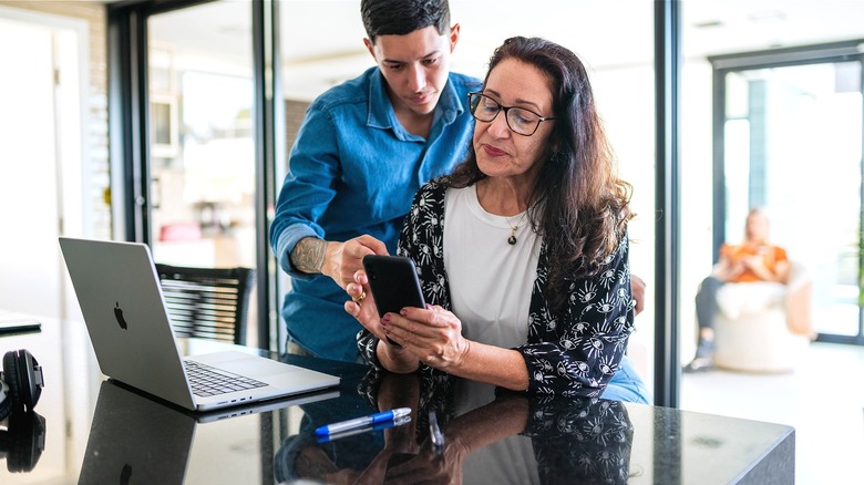 Son and mom reading smartphone