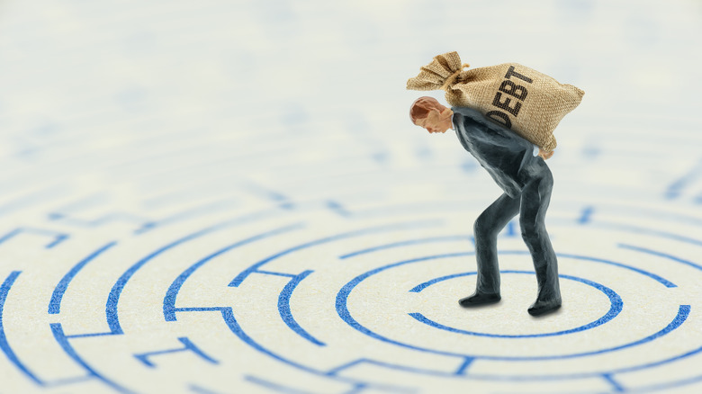 man holding debt in maze
