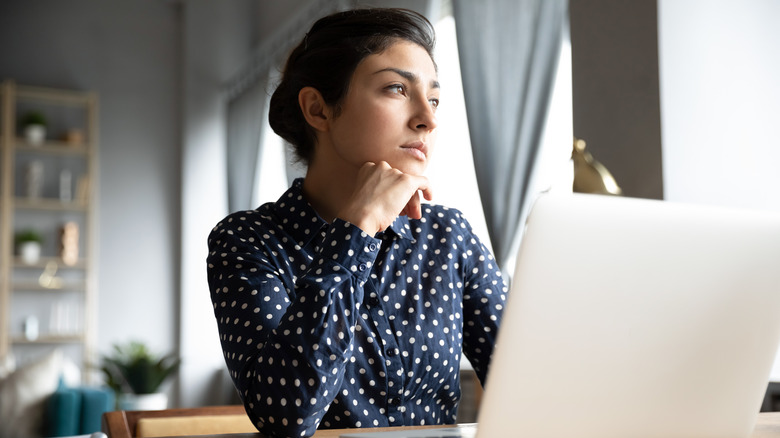 woman thinking at laptop